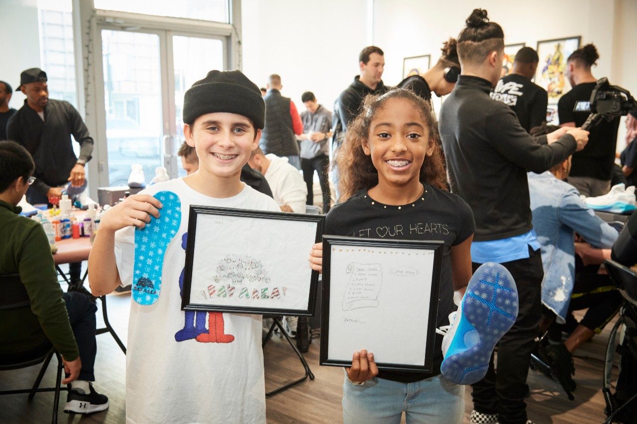 Brooklyn and Joaquin, participants in the FBCC Kids customization class, showcase drawings that inspired the new Curry 6 colorway