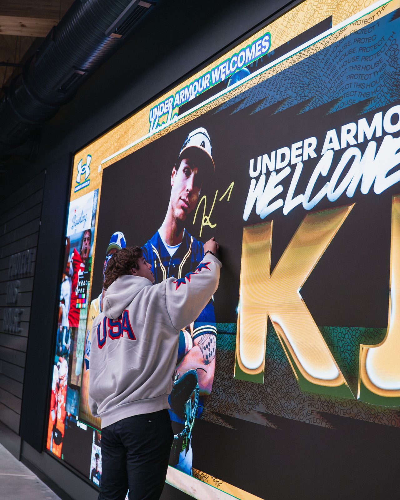 KJ at UAHQ Signing Make You Famous Wall