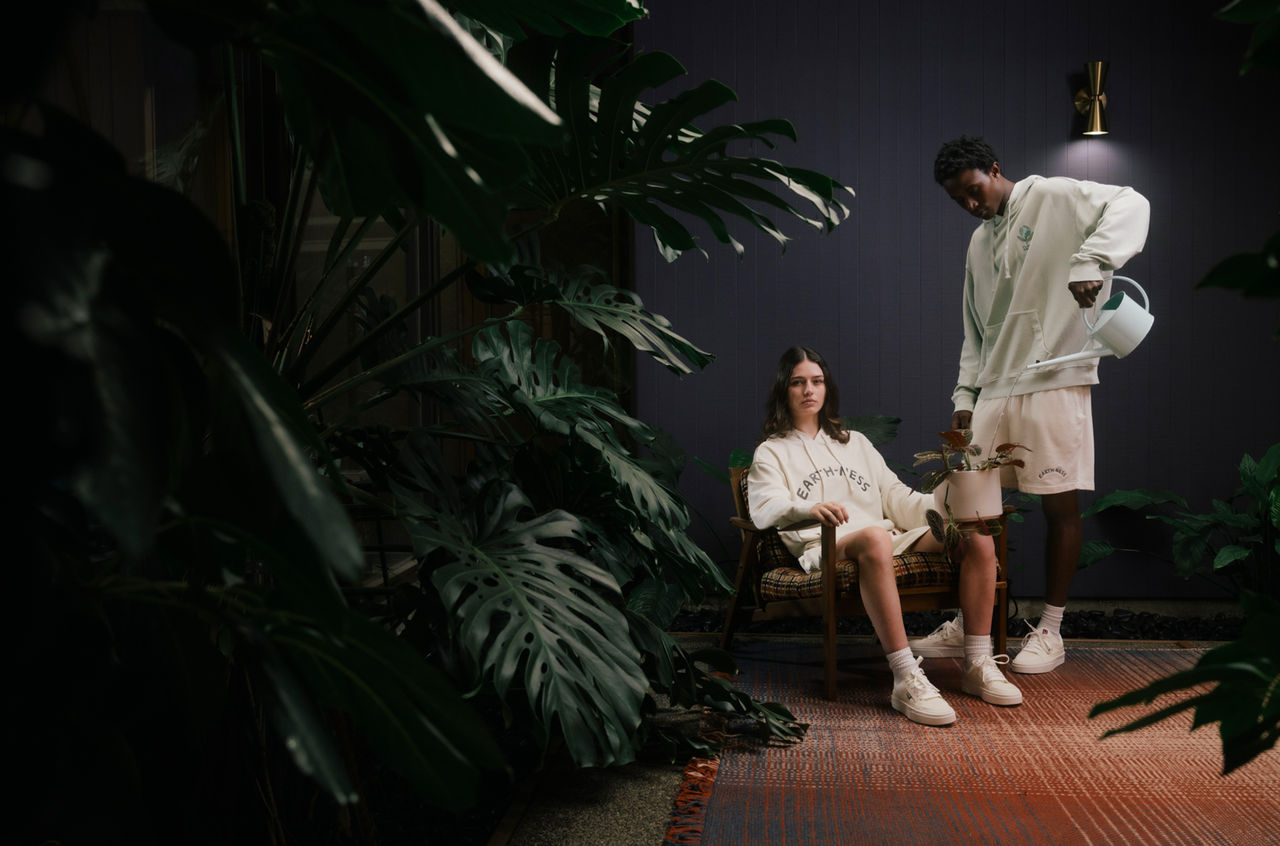 Male and female model showing Earth Day clothes by a tree