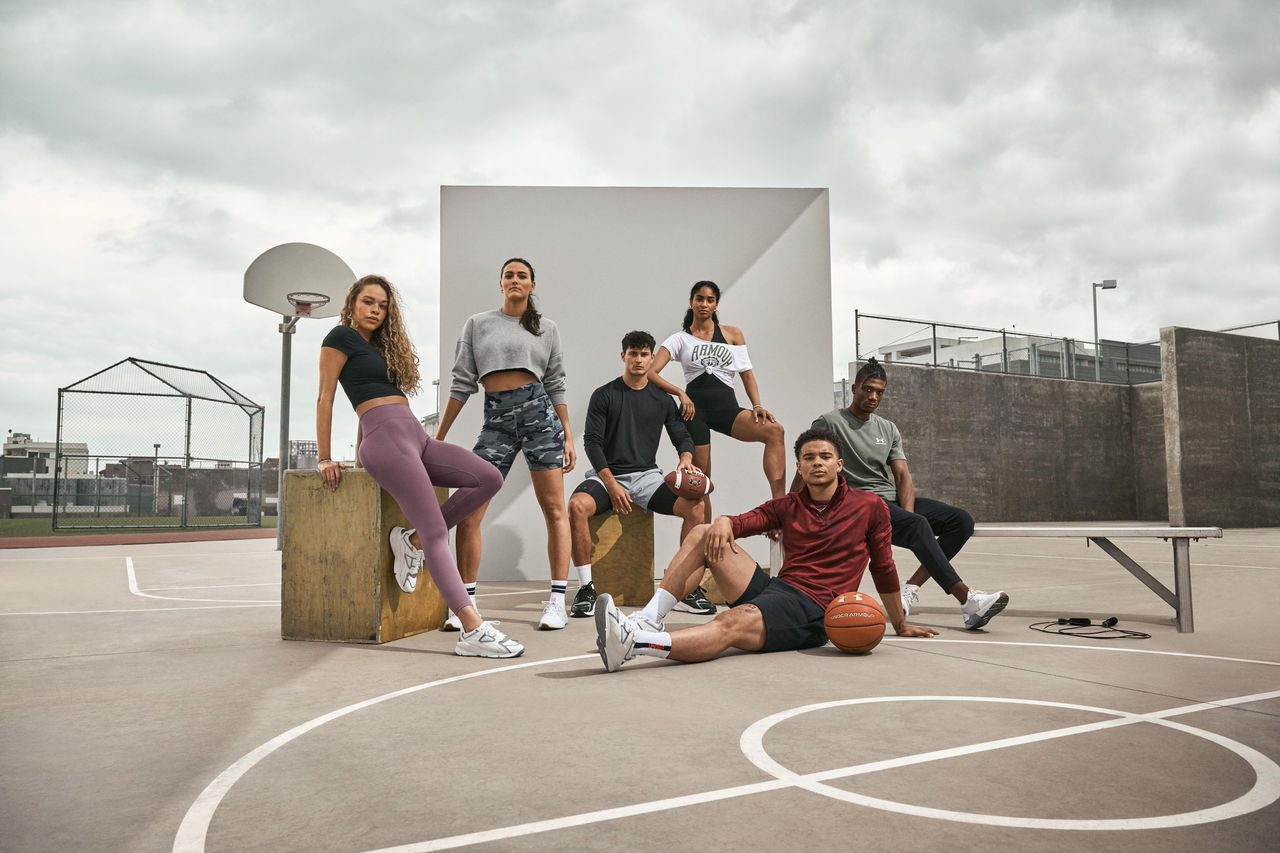 Athletes posing in UA gear on basketball court