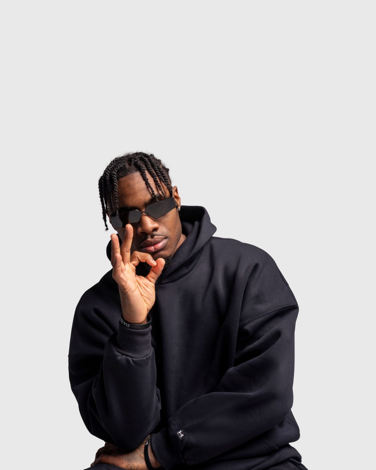 Davion Mitchell con una sudadera con capucha negra con tres letreros