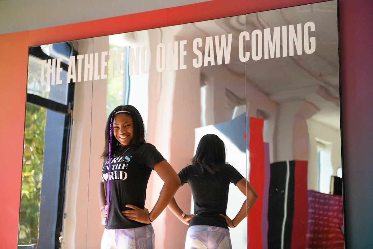 Young Female Athlete in front of "Athlete No One Saw Coming" Photo Op