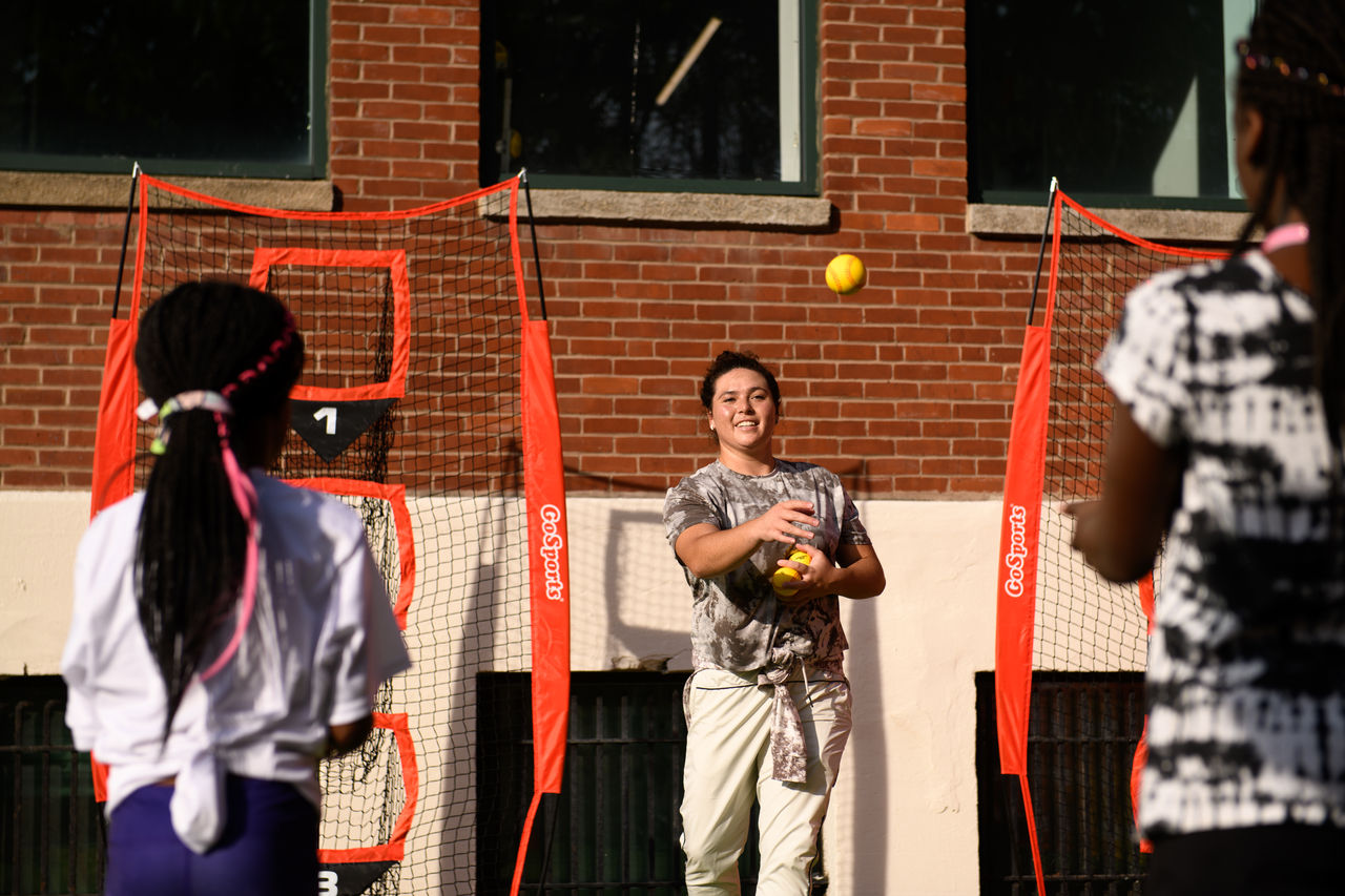 Rachel Garcia, professional softball player for the US National Team, throwing with young female athletes