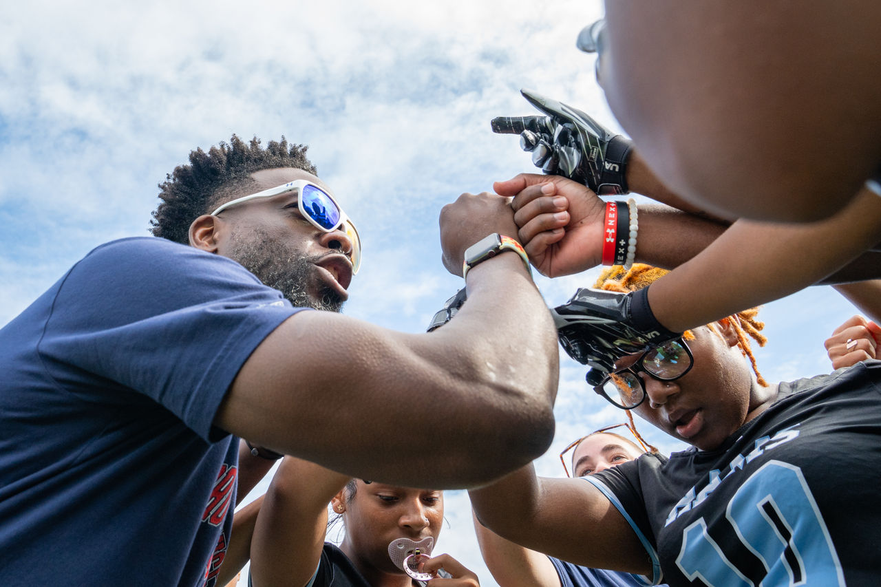 UA Teammate Huddles with Baltimore Students