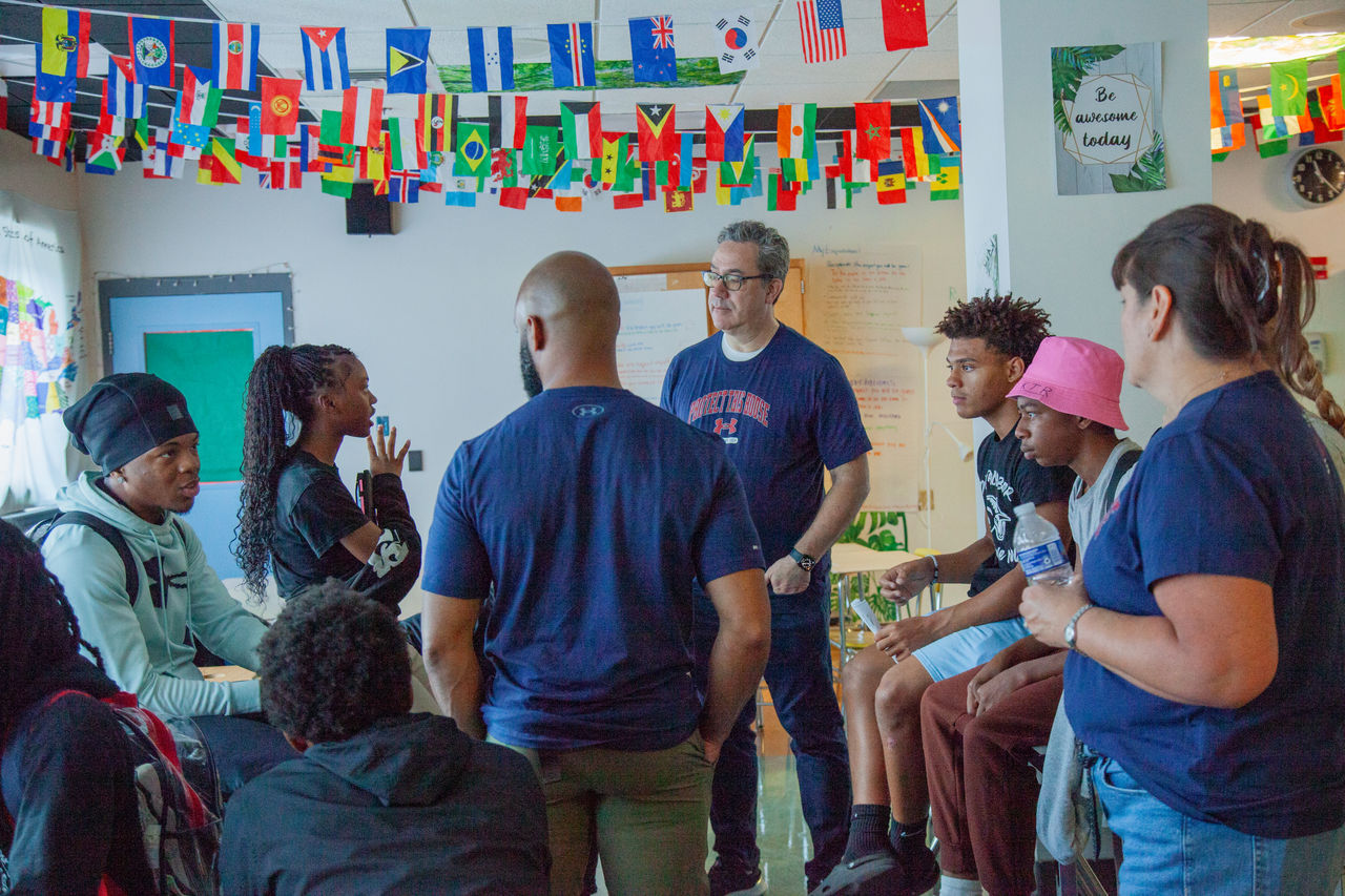 UA Teammate Huddles with Baltmore Students discussing Industry Careers