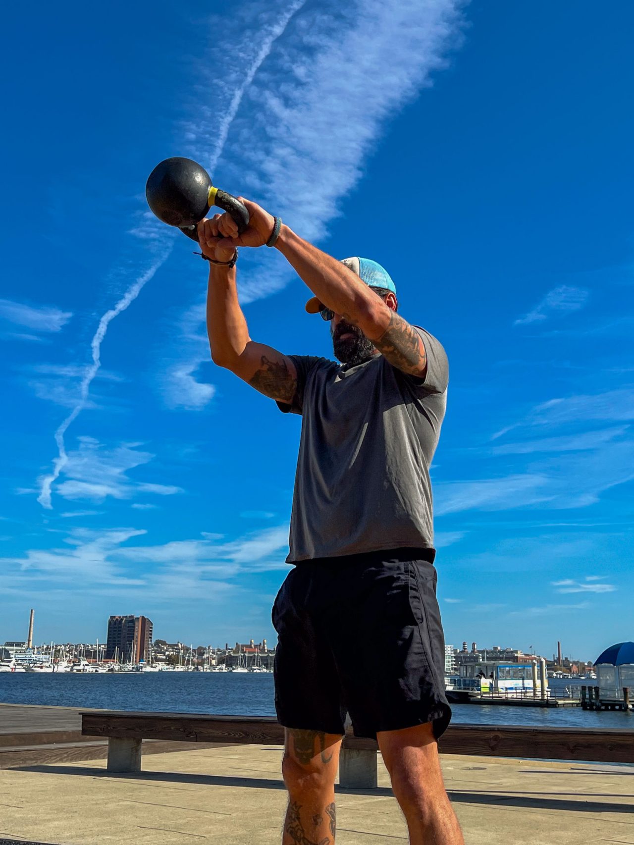 Athlete on UA HQ field kettle bell swings