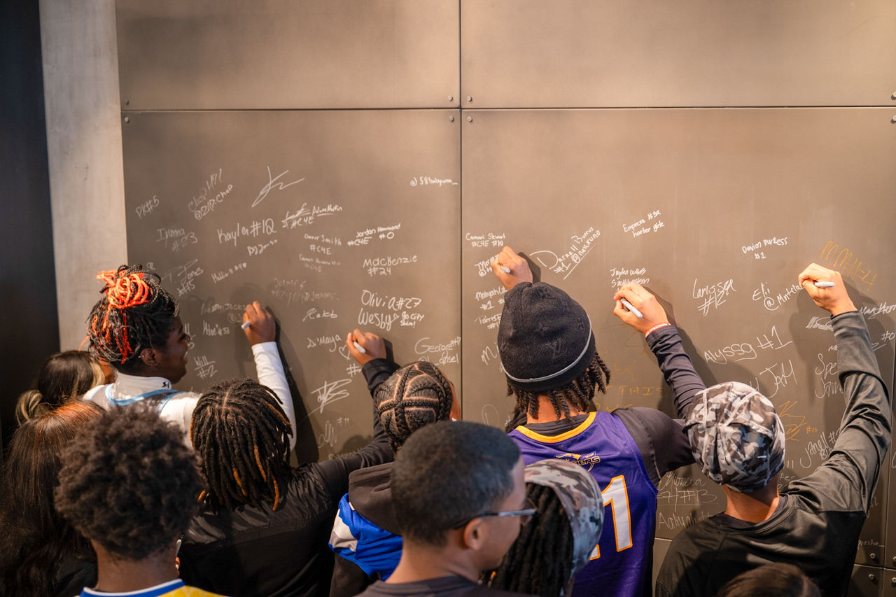 Student athletes sign flagship store athlete wall